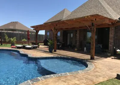 Backyard swimming pool with pergola-covered patio and lounge seating