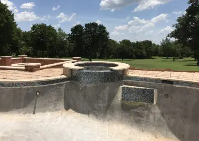 Swimming pool under construction with raised circular spa and mosaic tile band