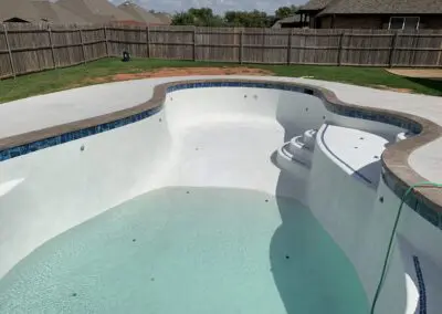 Residential backyard swimming pool under construction with shallow water and steps