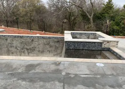 Unfinished concrete pool and raised spa with tiled coping and surrounding patio