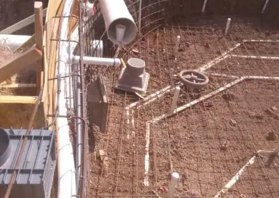 In-ground pool plumbing and rebar installation before concrete pour