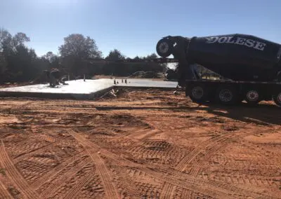 cement foundation poured at construction site with mixer truck and workers