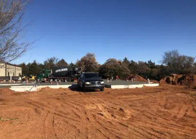 Truck and car at construction site pouring concrete slab