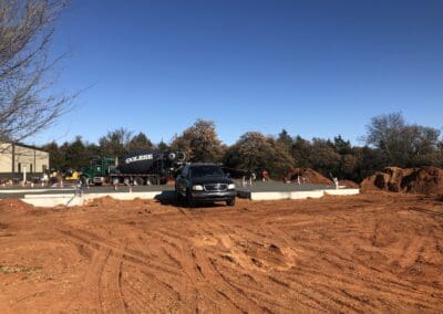 Truck and car at construction site pouring concrete slab